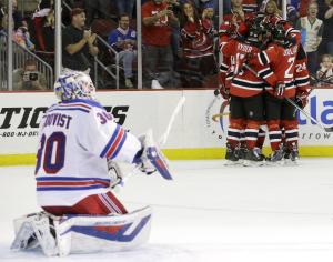 Helpless Hank: Henrik Lundqvist watches the Devils celebrate their fourth goal.  AP Photo/Julio Cortez