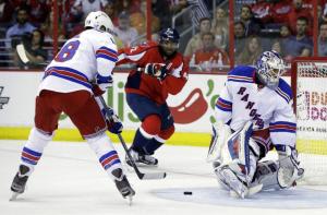Marc Staal clears a puck as Henrik Lundqvist watches closely. AP Photo/Alex Brandon