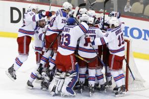 An excited bunch of Rangers celebrate their second round series victory by mobbing Henrik Lundqvist. Associated Press/Getty Images