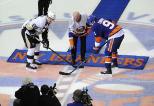 Islanders great Billy Smith drops the ceremonial first puck with John Tavares and Sidney Crosby at center ice. AP Photo by Kathy Kmonicek/Getty Images
