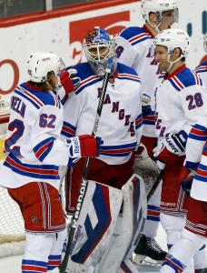 Metro Champs: Winning netminder Henrik Lundqvist gets congrats from Carl Hagelin (left) and Dominic Moore (right) after the Rangers clinched the Metro Division with a 3-2 win over the Wild Thursday night. AP Photo by Jim Mone/Getty Images