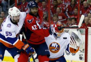 Johnny Boychuk battles Joel Ward in front of Jaroslav Halak. AP Photo by Alex Brandon/Getty Images